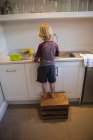 Rear view of boy working in kitchen at home — Stock Photo