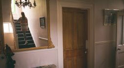Rückansicht einer Frau, die zu Hause die Treppe hinauf geht — Stockfoto