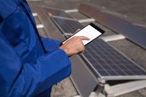 Mid section of male worker using digital tablet at solar station — Stock Photo