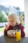 Мальчик завтракает дома на крыльце — стоковое фото