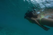Woman in bikini scuba diving underwater in turquoise sea — Stock Photo