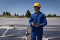 Männlicher Arbeiter an einem sonnigen Tag mit digitalem Tablet an der Solarstation — Stockfoto