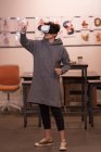 Jovem executiva usando fone de ouvido de realidade virtual no escritório . — Fotografia de Stock