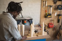 Carpenter preparing wooden column in workshop — Stock Photo