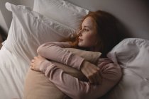 Donna premurosa rilassante sul letto in camera da letto a casa — Foto stock