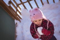 High angle of cute girl licking snow during winter — Stock Photo