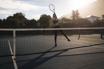 Giovane donna che pratica il tennis nel campo da tennis — Foto stock