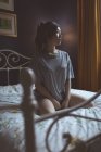 Mujer reflexiva relajarse en el dormitorio en casa - foto de stock