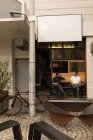 Hommes interagissant sur le banc dans le café trottoir — Photo de stock