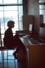 Femme travaillant sur ordinateur au bureau de la bibliothèque — Photo de stock