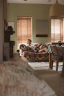 Donna che utilizza il telefono cellulare sul divano in soggiorno a casa — Foto stock
