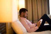 Empresário usando tablet digital no quarto de hotel — Fotografia de Stock