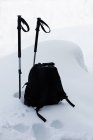 Nahaufnahme eines Rucksacks mit Skistöcken in einer verschneiten Landschaft — Stockfoto