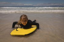 Portrait of happy girl surfing at beach — Stock Photo