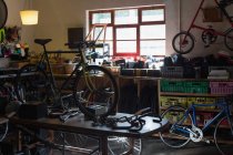 Componenti per biciclette e biciclette su un tavolo in officina — Foto stock