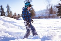 Милий хлопчик грає в сніг взимку — стокове фото