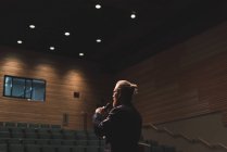 Hombre practicando el habla con micrófono en el escenario en el teatro . - foto de stock