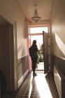 Rückansicht Frau mit Rucksack öffnet Wohnungstür — Stockfoto