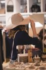 Mädchen probiert Hut in Einkaufszentrum aus — Stockfoto