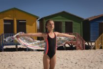 Glückseliges Mädchen mit Handtuch am Strand an einem sonnigen Tag — Stockfoto