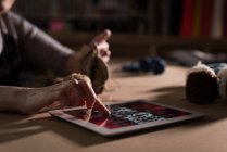 Nahaufnahme einer Strickerin in einer Schneiderei mit digitalem Tablet — Stockfoto