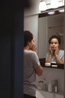 Красива жінка захоплюється собою перед дзеркалом — стокове фото