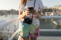Media sezione di donna che utilizza il telefono cellulare sulla nave da crociera — Foto stock