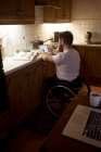 Людина з обмеженими можливостями використовує цифровий планшет на кухні вдома — стокове фото