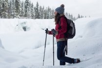 Жіночий гірськолижник, що ходить у засніженому пейзажі взимку — стокове фото