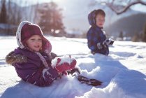 Братья и сестры зимой играют на снегу — стоковое фото