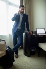 Бізнесмен розмовляє на мобільному телефоні в готельному номері — стокове фото