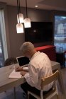 Homme d'affaires prenant des notes sur un carnet dans la chambre d'hôtel — Photo de stock