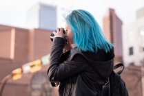 Stylish woman photographing with camera in city street — Stock Photo