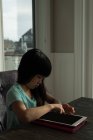Chica usando tableta digital en casa - foto de stock