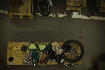Frais généraux des pièces de moto disposées sur la table dans le garage — Photo de stock