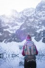Donna in piedi con zaino sul lungolago durante l'inverno — Foto stock