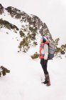 Frau steht im Winter mit Rucksack — Stockfoto