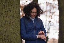 Молода жінка використовує смарт-годинник у парку — стокове фото
