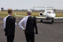 Вид ззаду двох пілотів-чоловіків, що стоять на зсуві — стокове фото