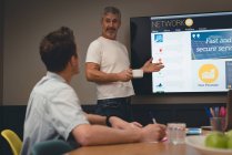Бізнесмен дає презентацію колегам в конференц-залі в офісі — стокове фото