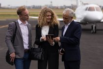 Gli uomini d'affari discutono su tablet digitale in fuga — Foto stock