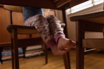 Low section of little girl sitting on chair at home — Stock Photo
