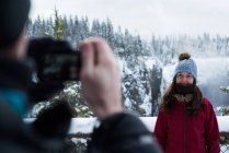 Hombre tomando fotos de mujer con cámara durante el invierno - foto de stock