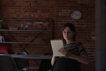 Женщина-руководитель с помощью цифрового планшета в офисе — стоковое фото