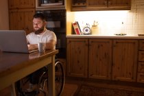 Giovane disabile che utilizza il computer portatile a casa — Foto stock