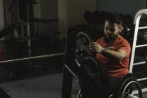 Behinderter stellt Langhantel in Turnhalle ein — Stockfoto