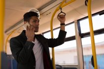 Jovem empresário falando no celular enquanto viaja no ônibus — Fotografia de Stock