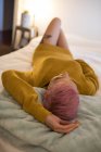 Mujer joven con el pelo rosa durmiendo en el dormitorio en casa . - foto de stock
