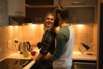 Couple s'embrassant dans la cuisine à la maison — Photo de stock