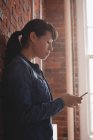Жіночий керівник використовує мобільний телефон у творчому офісі — стокове фото